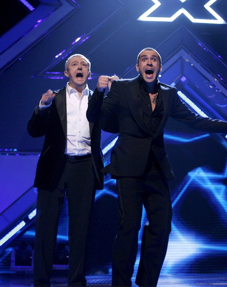 two men on a stage with a rex logo in the corner