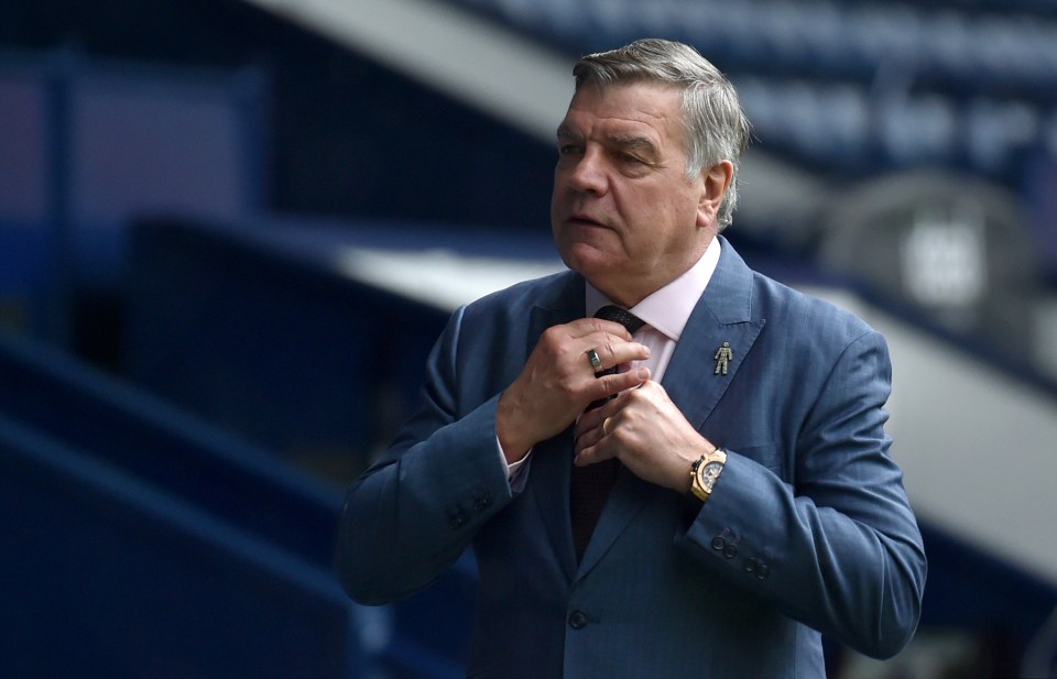 a man in a suit adjusts his tie while wearing a watch