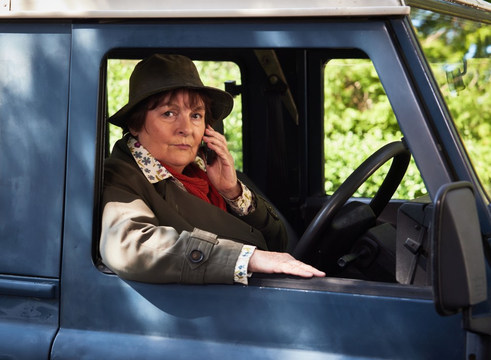 a woman in a hat is talking on a cell phone