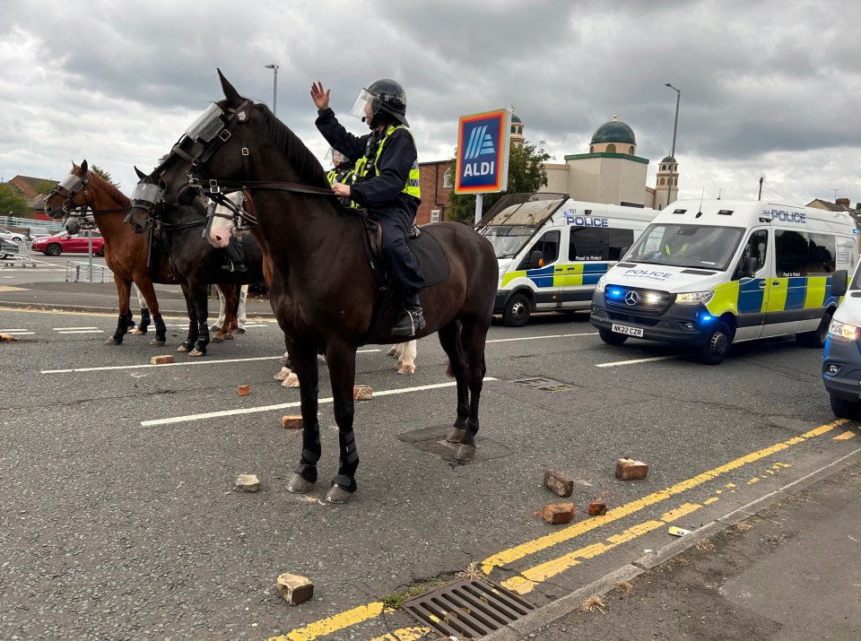 a man on a horse stands in front of a sign that says aldi