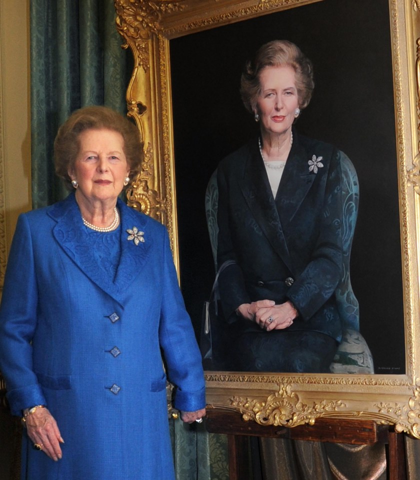 a woman in a blue coat stands in front of a portrait of herself