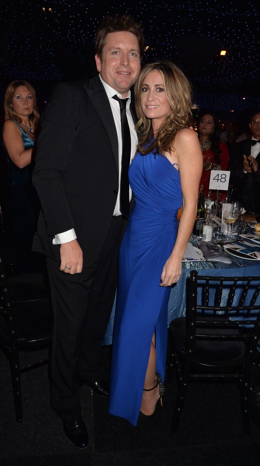 a man and woman pose in front of a table number 48