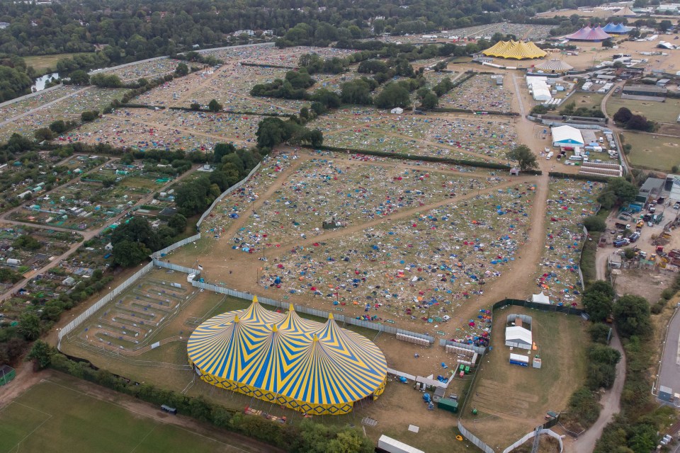 an aerial view of a festival with a large yellow and blue tent in the middle