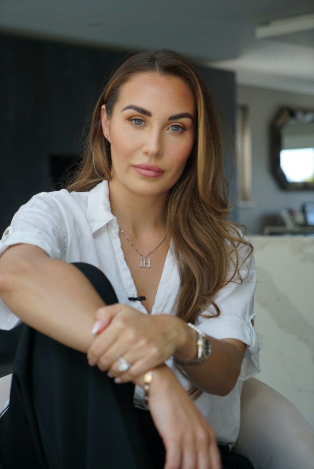 a woman wearing a necklace with the letter h on it