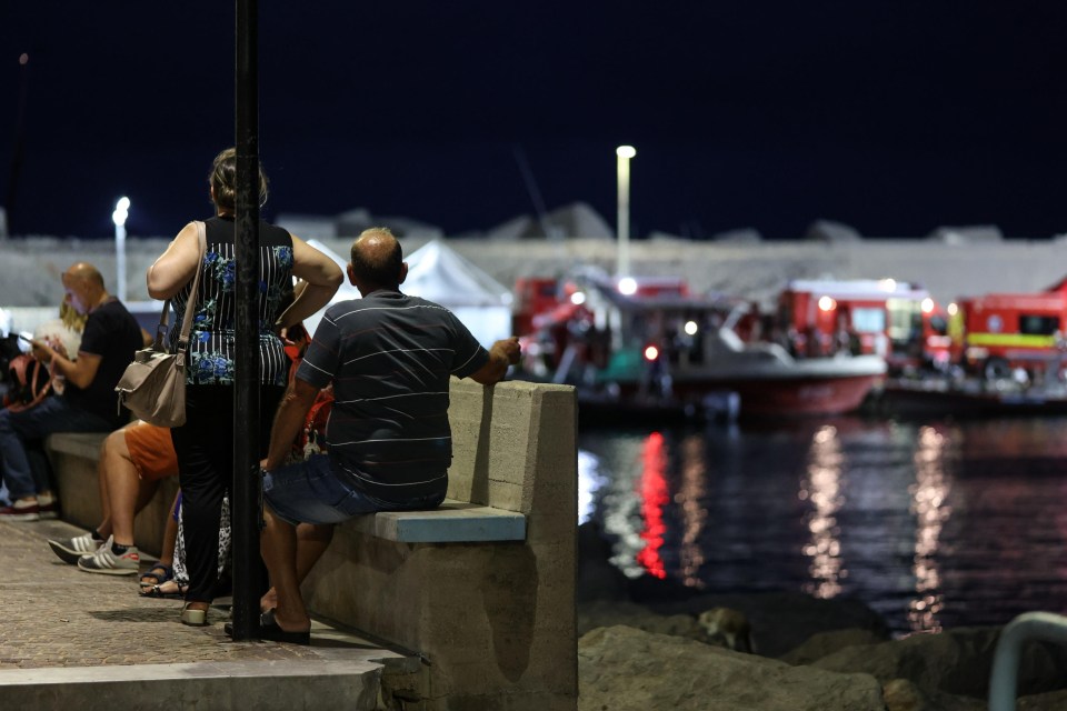 a man sits on a bench looking at the water