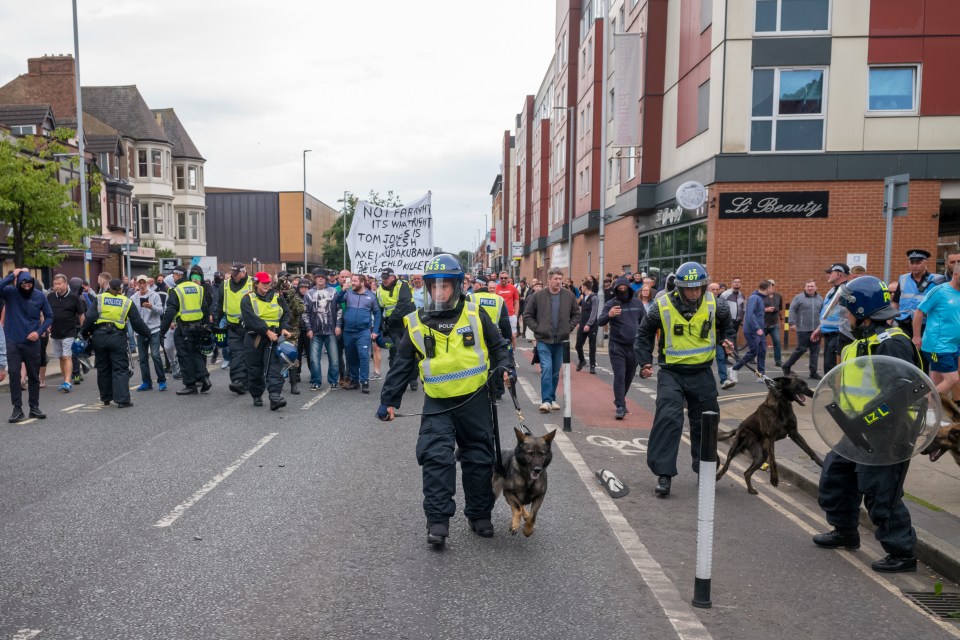 a group of police officers walking down a street with a sign that says ' not family ' on it