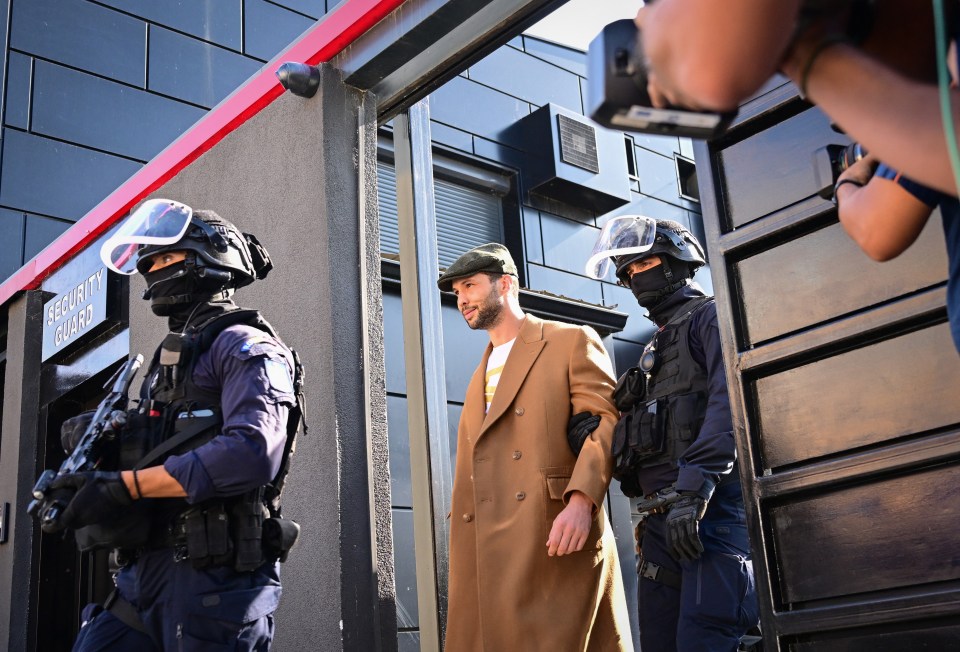 a man standing in front of a building that says security guard