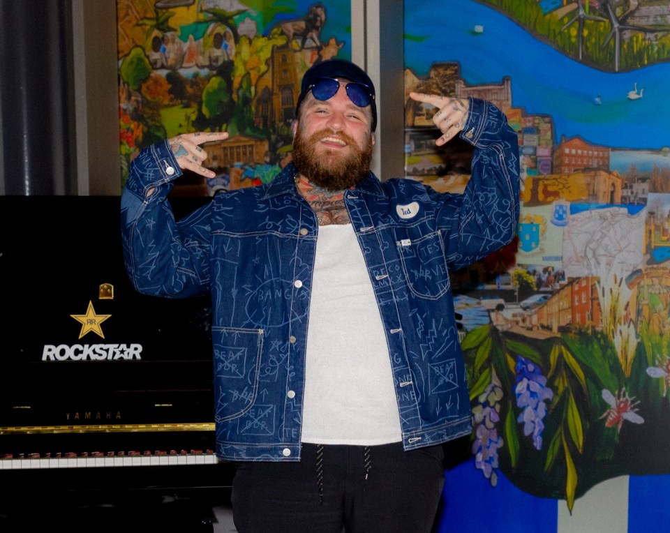 a man standing in front of a rockstar piano