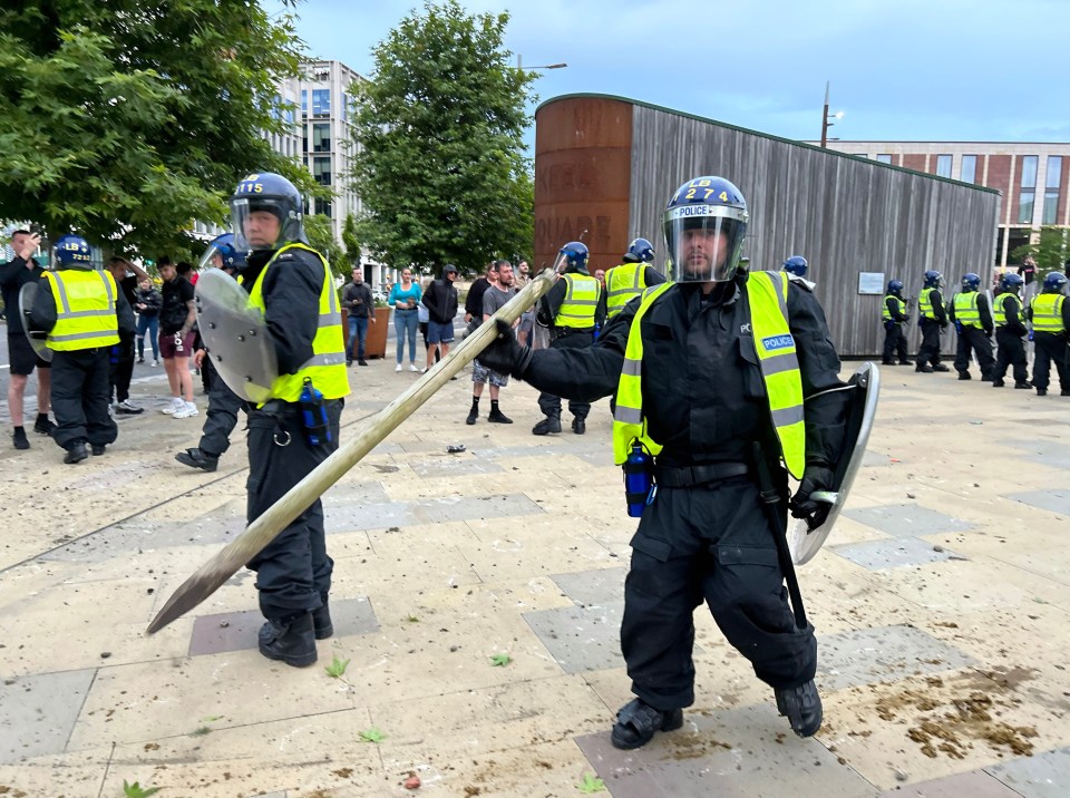 a group of police officers are standing in front of a wooden building that says ' tower ' on it
