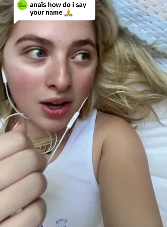 a woman wearing headphones is laying on a bed