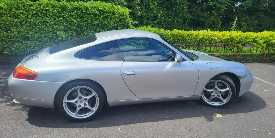 a silver porsche is parked in a parking lot