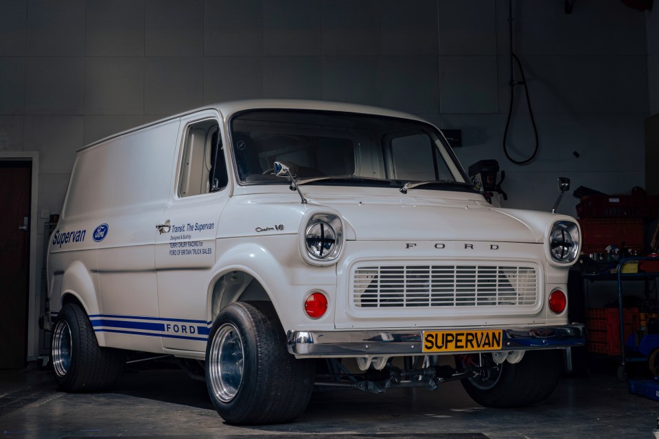 a white ford van is parked in a garage