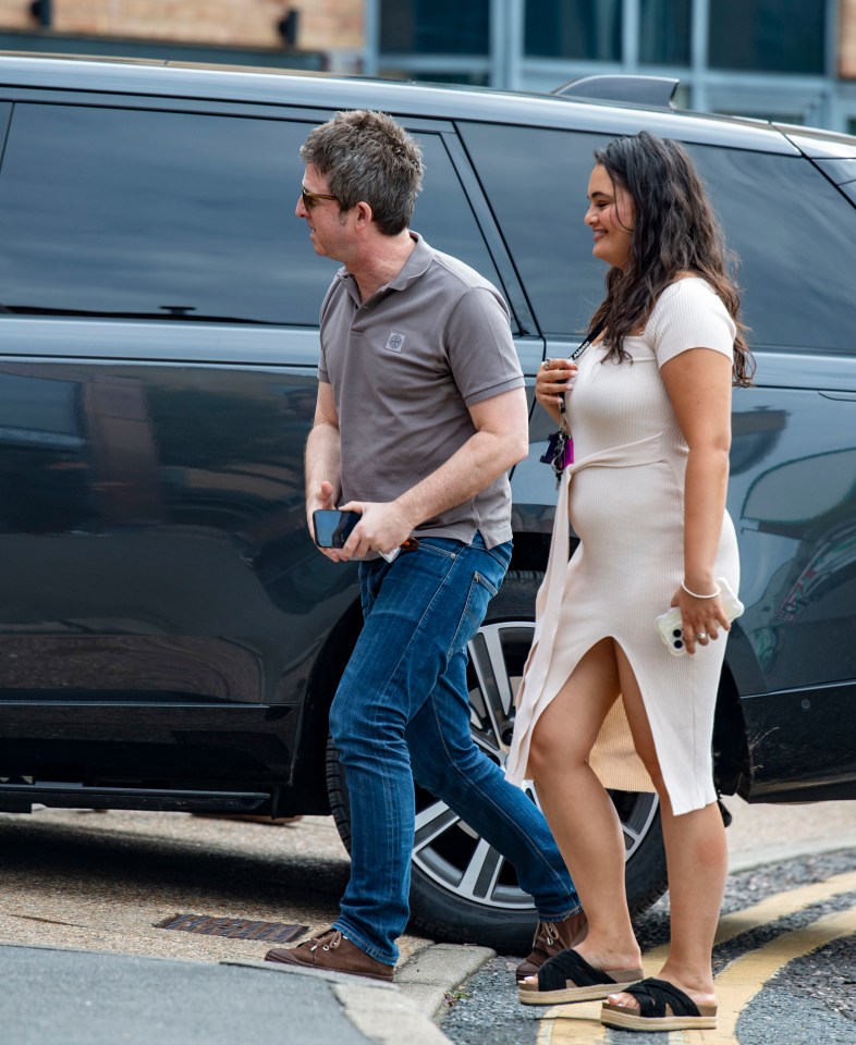 a woman in a white dress is walking next to a man in a grey shirt