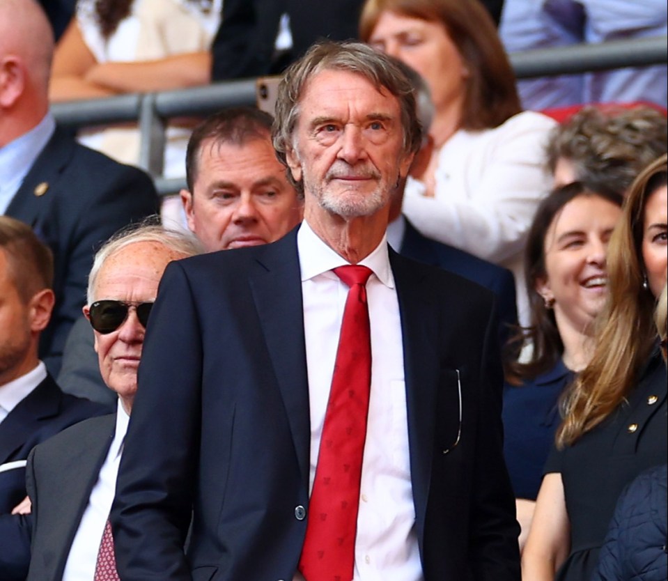 a man in a suit and red tie stands in the stands