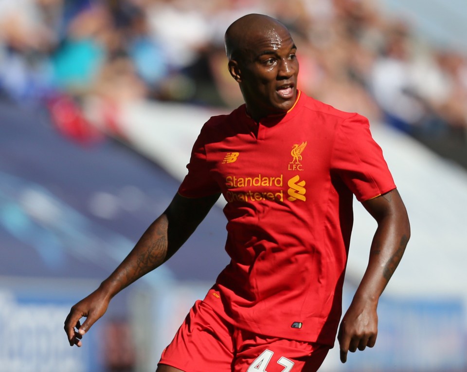 a soccer player wearing a red shirt that says standard chartered