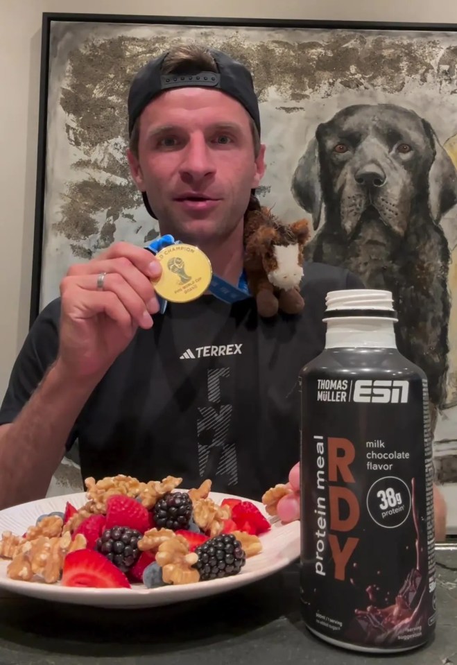 a man holding a gold medal next to a bottle of protein meal rdy