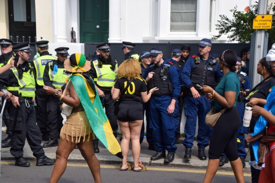 Alamy Live News. 2XXW33W London, England, UK. 26th Aug, 2024. A woman taks to police officers as they detain several men on the second day of the Notting Hill Carnival as security is increased following stabbings and arrests on the previous day. (Credit Image: Â¿ Vuk Valcic/ZUMA Press Wire) EDITORIAL USAGE ONLY! Not for Commercial USAGE! This is an Alamy Live News image and may not be part of your current Alamy deal . If you are unsure, please contact our sales team to check.