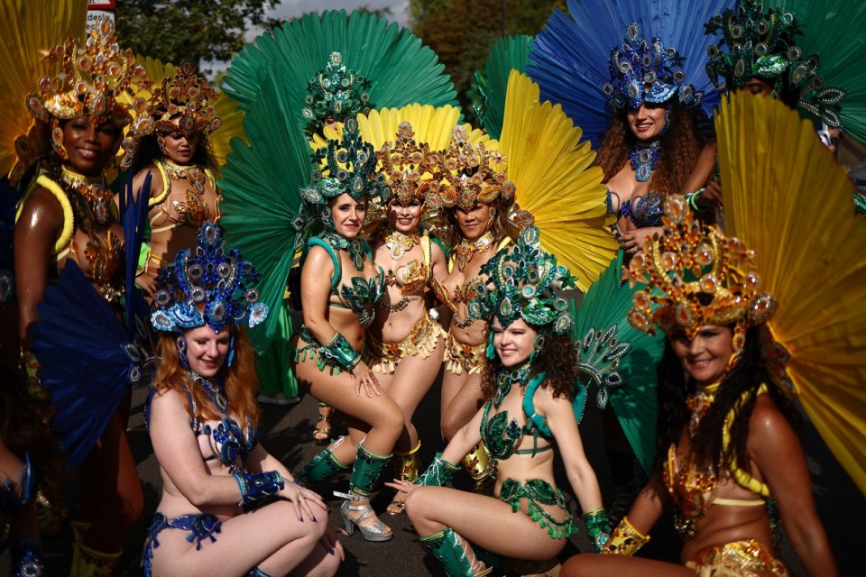 Performers in costume pose for a photo as they prepare to take part in the main parade of the Notting Hill Carnival in west London on August 26, 2024. (Photo by HENRY NICHOLLS / AFP) (Photo by HENRY NICHOLLS/AFP via Getty Images)