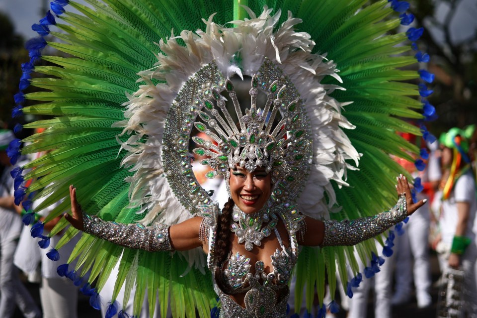 A performer in costume poses for a photo as they prepare to take part in the main parade of the Notting Hill Carnival in west London on August 26, 2024. (Photo by HENRY NICHOLLS / AFP) (Photo by HENRY NICHOLLS/AFP via Getty Images)