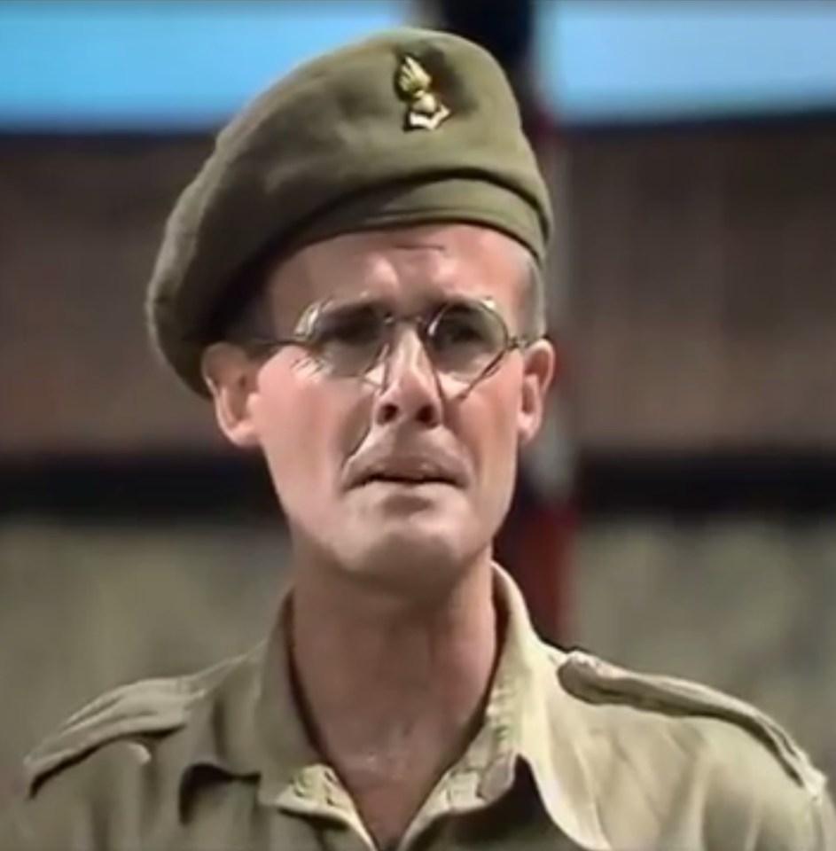 a man in a military uniform is wearing glasses and a beret .