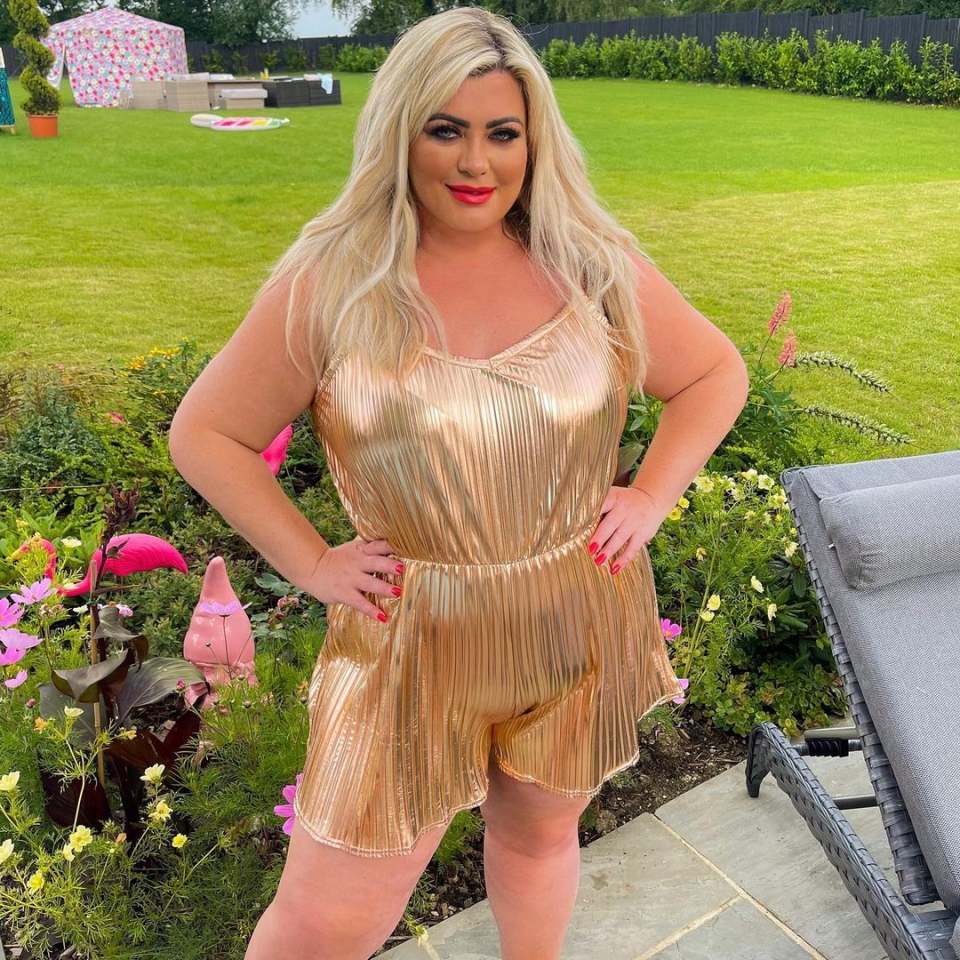 a woman in a gold dress is standing in a garden