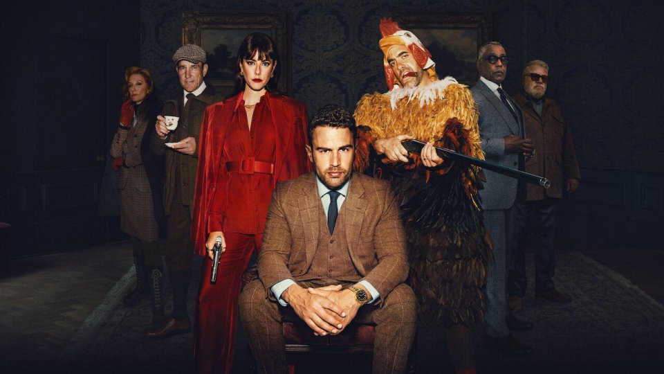 a man in a suit sits in front of a group of people