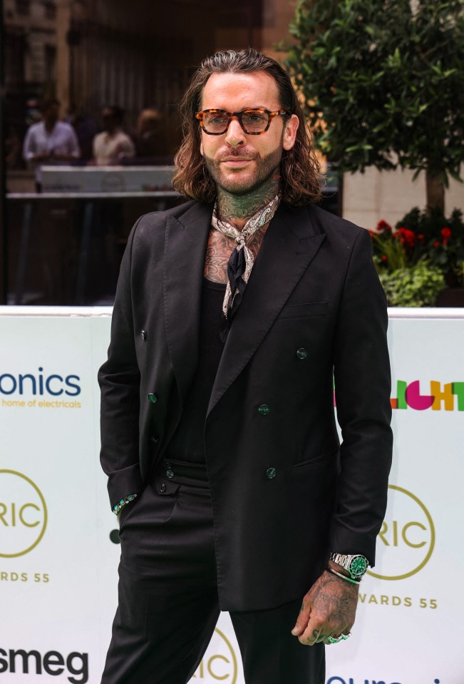 a man in a suit stands in front of a smeg sign