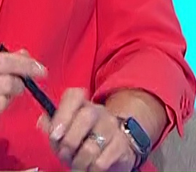 a woman in a red shirt is holding a cell phone in her hands .