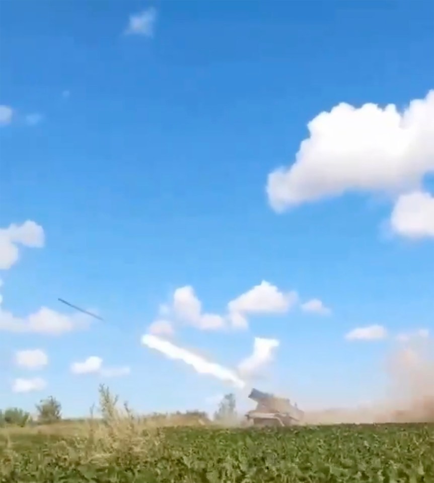 a rocket is being launched from a tank in a field .