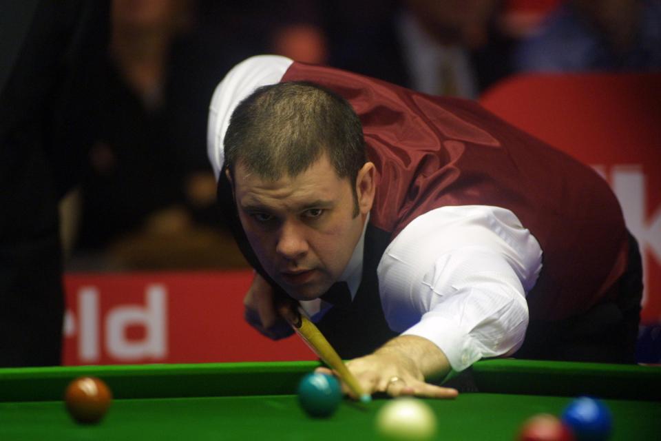 a man in a red vest is playing snooker