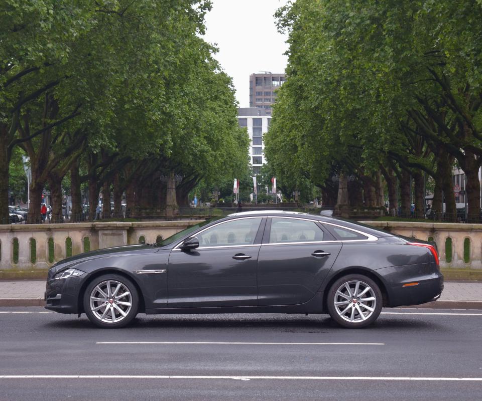 a car is driving down a street with trees in the background