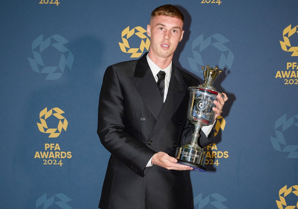 a man holding a trophy in front of a wall that says pfa awards 2024