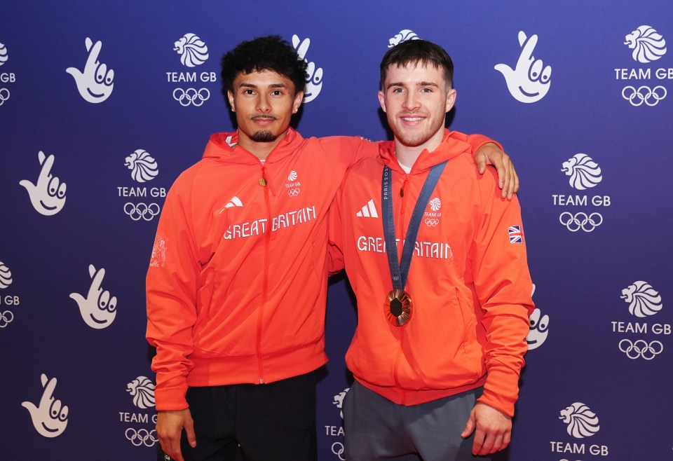 two athletes are posing for a team gb photo