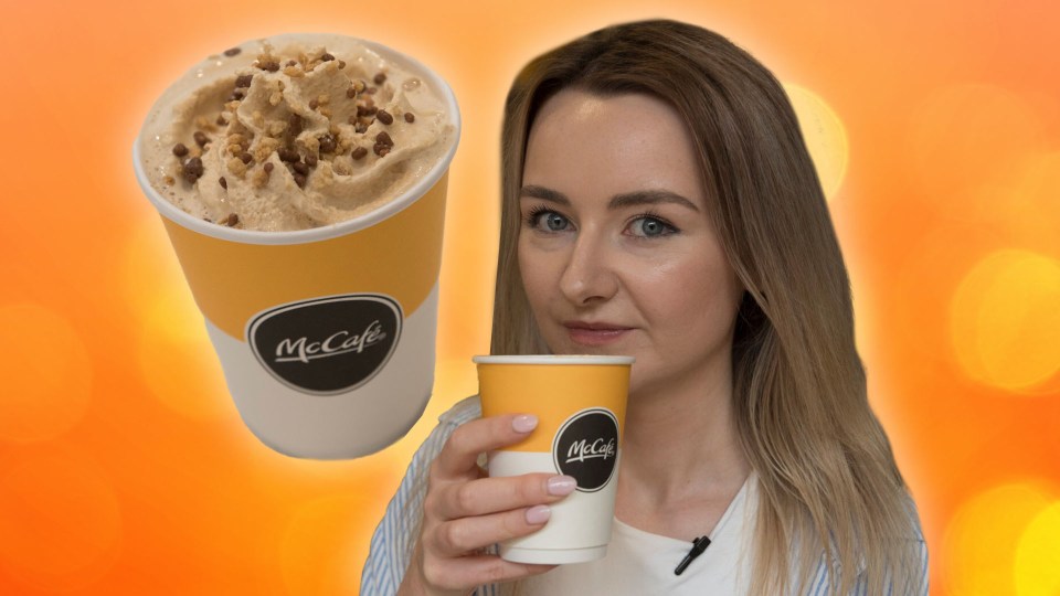 a woman is holding a cup of mccafe coffee
