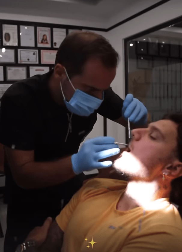 a man is getting his teeth examined by a dentist