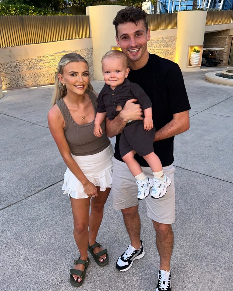 a man and woman holding a baby in their arms