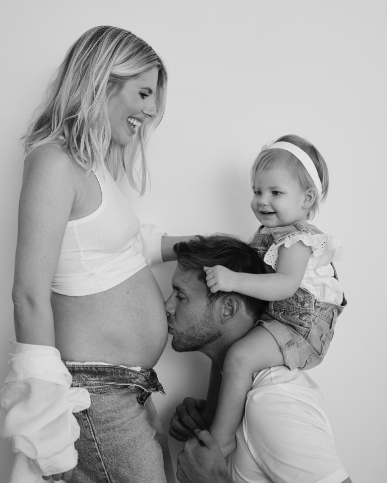 a man kisses the belly of a pregnant woman