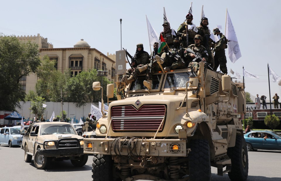 a group of soldiers are riding on top of a military vehicle