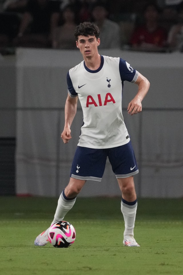 a soccer player wearing an aia jersey kicks the ball