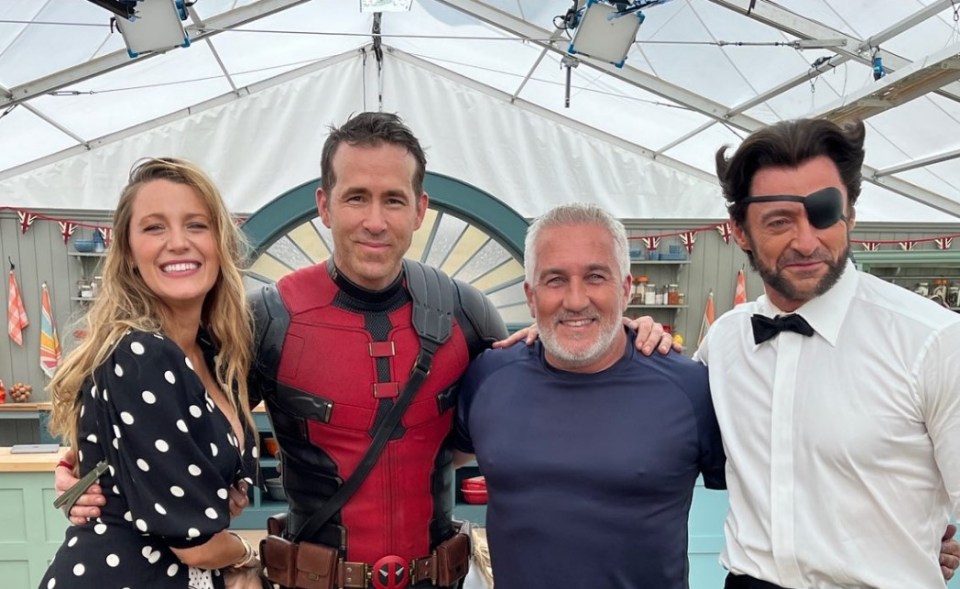 a group of people posing for a picture with one wearing a deadpool costume