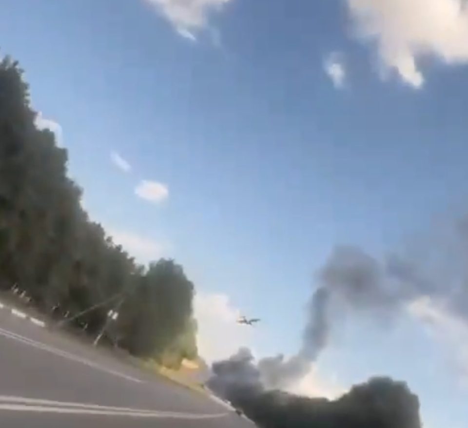 a plane is flying over a road with smoke coming out of it .