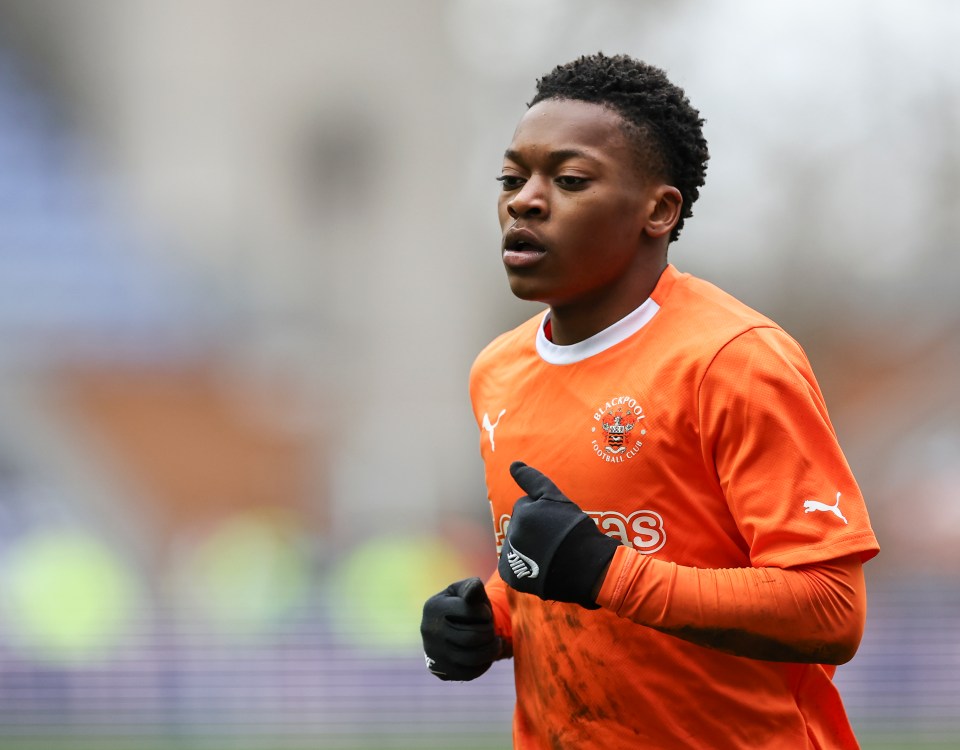 a soccer player wearing an orange jersey with a puma logo