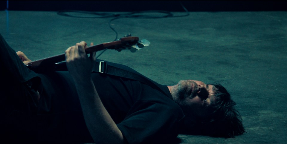 a man laying on the floor playing a guitar