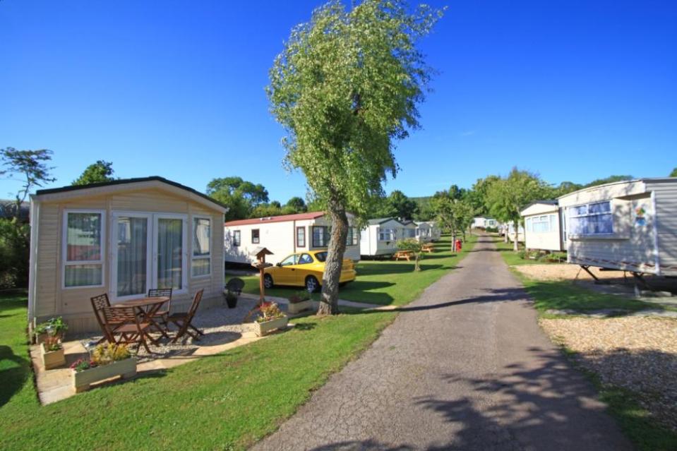 a yellow car is parked in front of a mobile home