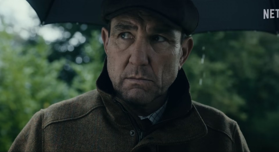 a man holding an umbrella with a netflix logo behind him