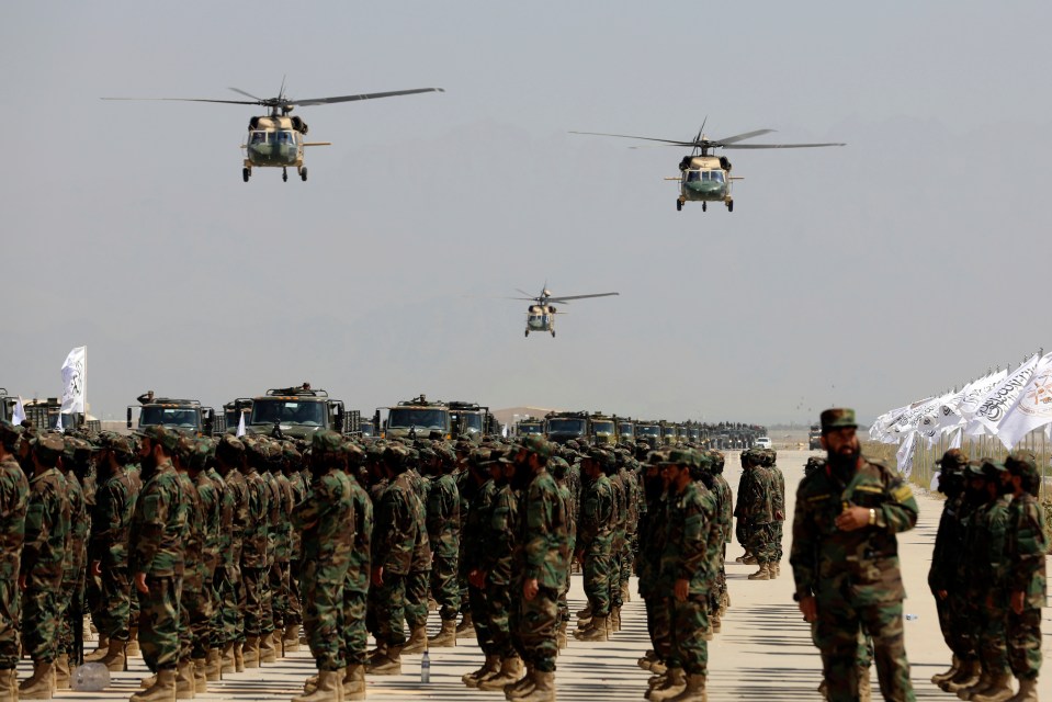 a group of soldiers are lined up in front of flags that say afghanistan