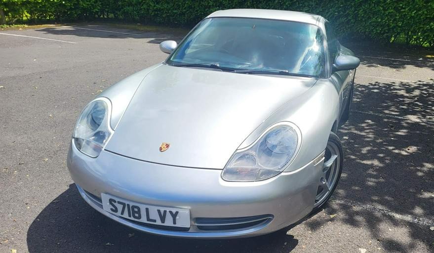 a silver porsche with a license plate that says s718 lvy