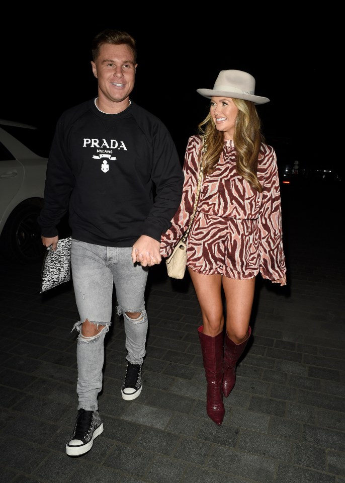 a man wearing a prada sweatshirt holds hands with a woman