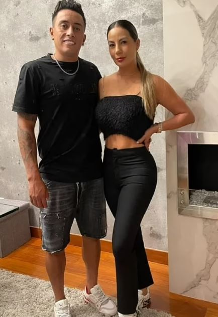 a man and a woman are posing for a picture in a living room .