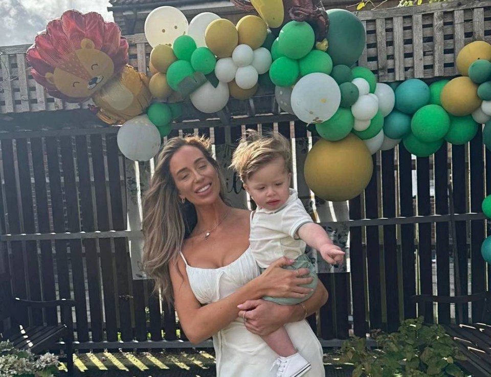 a woman in a white dress is holding a baby in front of balloons with the words wild one theme below her
